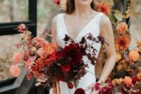 an ombre wedding bouquet of coral and peachy dahlias and roses, burgundy dahlias, roses and raunuculus, leaves