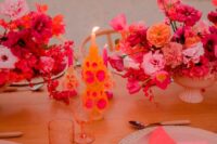 bright wedding centerpiece of light pink and fuchsia blooms and bold candles for a bright tropical wedding