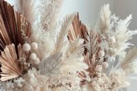 gorgeous wedding centerpieces of dried fronds, pampas grass and leaves, dried seed pods look very chic and are gorgeous for a modern wedding