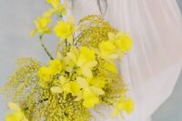 02 a bold spring wedding bouquet with mimosa and daffodils is a bright touch of color perfect for a neutral bridal look