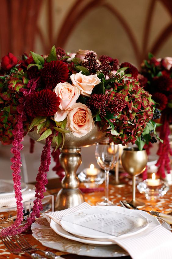 a decadent wedding centerpiece of blush roses, burgundy mumes, berries, greenery and amaranthus is a very refined solution