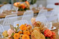 03 a beautiful and bold wedding centerpiece of marigolds, dahlias, roses, greenery and leaves is a cool solution for a fall wedding