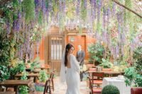 03 a beautiful and dreamy wedding reception space with wisteria naturally gorwing over it and lots of greenery and lavender around