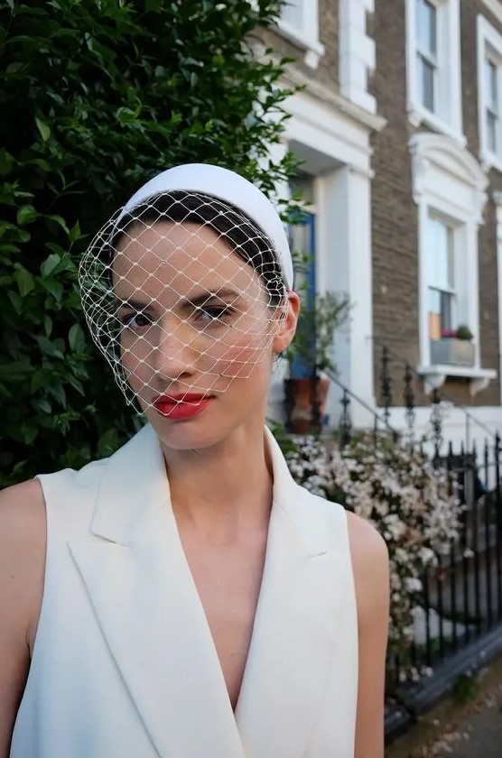 a birdcage veil with a white headband is a modern and bold idea for a refined bride