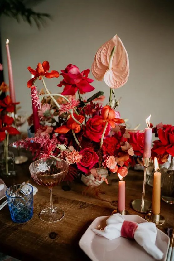 a beautiful and sumptuous wedding centerpiece with blush, red and orange blooms and blooming branches is a gorgeous idea