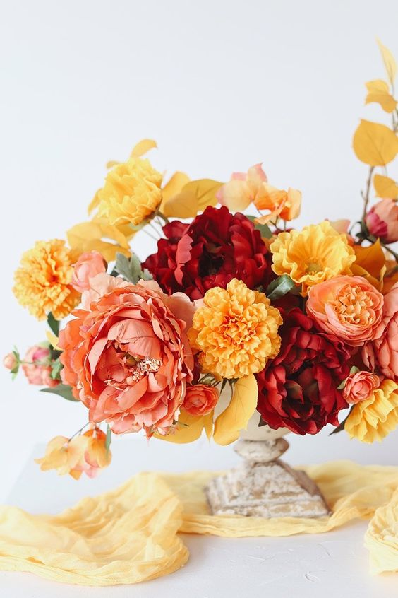 a beautiful wedding centerpiece of peonies and marigolds is a dreamy and catchy idea for a fall wedding