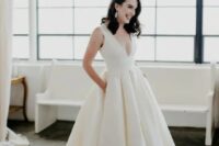 05 a gorgeous plain wedding ballgown with thick straps, a deep neckline and a pleated skirt with pockets and a train plus vintage statement earrings