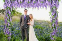 06 a bright wedding arch right in a blooming field, with wisteria and greenery hanging down is a cool idea for a boho wedding