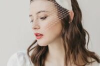 09 a mini birdcage veil with a large silk bow on top is a modern and bold idea for a fashion-forward bride