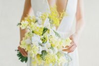 11 a delicate spring wedding bouquet of white and yellow blooms including mimosa and some greenery is wow