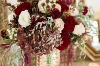 11 a luxurious floral centerpiece in the shades of ruby red, burgundy and white plus cascading blooms