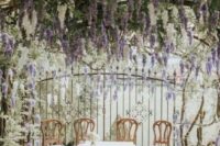 12 a dreamy wedding ceremony space with wisteria all around, with vintage chairs and greenery over the space is a lovely idea