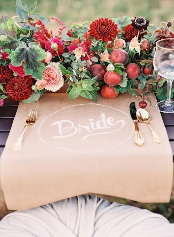 a bold wedding centerpiece of blush, burgundy blooms, greenery, berries and apples is a fantastic idea for a bright fall wedding