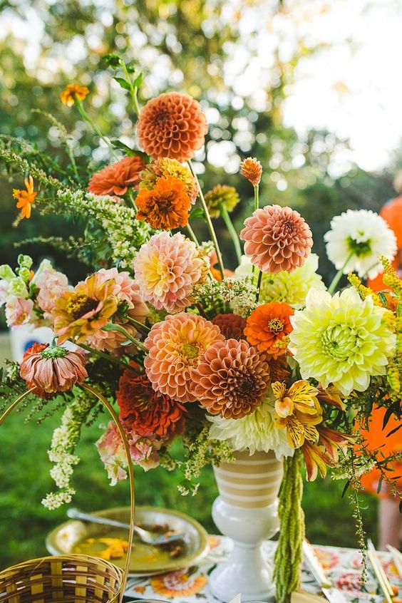 a bright wedding centerpiece of zinnias, dahlias and marigolds plus greenery is a cool idea for summer or fall
