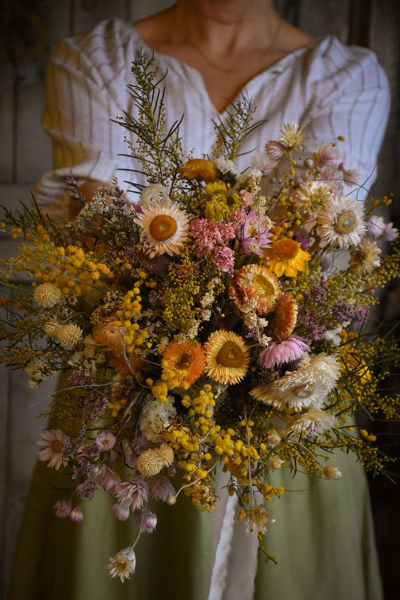 a lush dried flower wedding bouquet with mimosa, leaves and various blooms is a gorgeous idea for a wedding