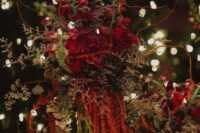 13 a moody forest wedding centerpiece of greenery, red blooms, amaranthus, twigs and branches is amazing