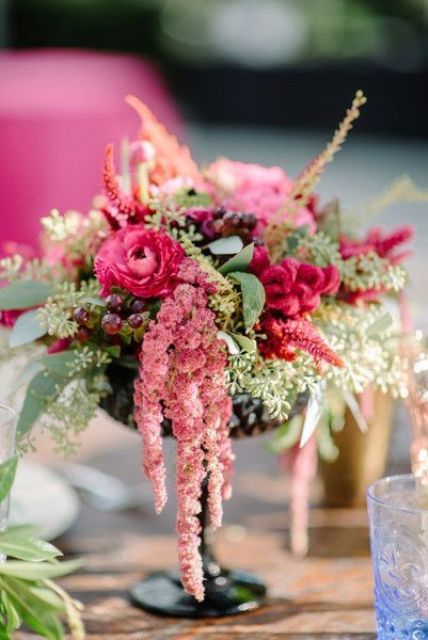 a bright wedding centerpiece of pink blooms, greenery, grapes, amaranthus is a super chic and cool idea for a summer wedding