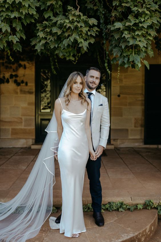 a silk slip maxi wedding dress paired with a long veil are a lovely idea for a modern or minimalist bride