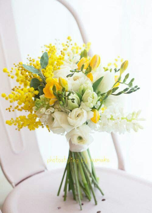 a lovely spring wedding bouquet of white tulips, ranunculus, mimosa and greenery is a cool and vivacious solution