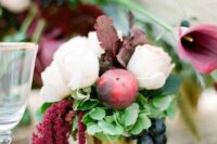17 a fall wedding centerpiece of blush peonies, a peach, grapes, amaranthus, grene hydrangeas and fall foliage