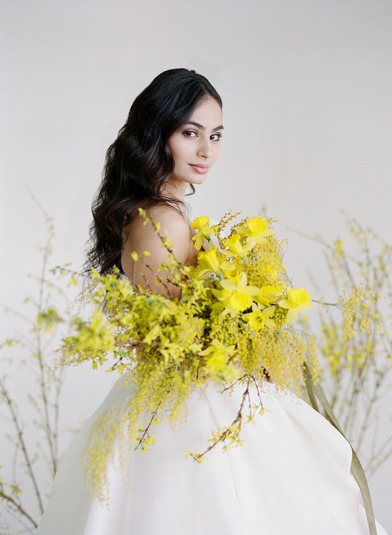 a pretty spring wedding bouquet in yellows, with mimosa is a catchy idea for a spring bride and a bold wedding