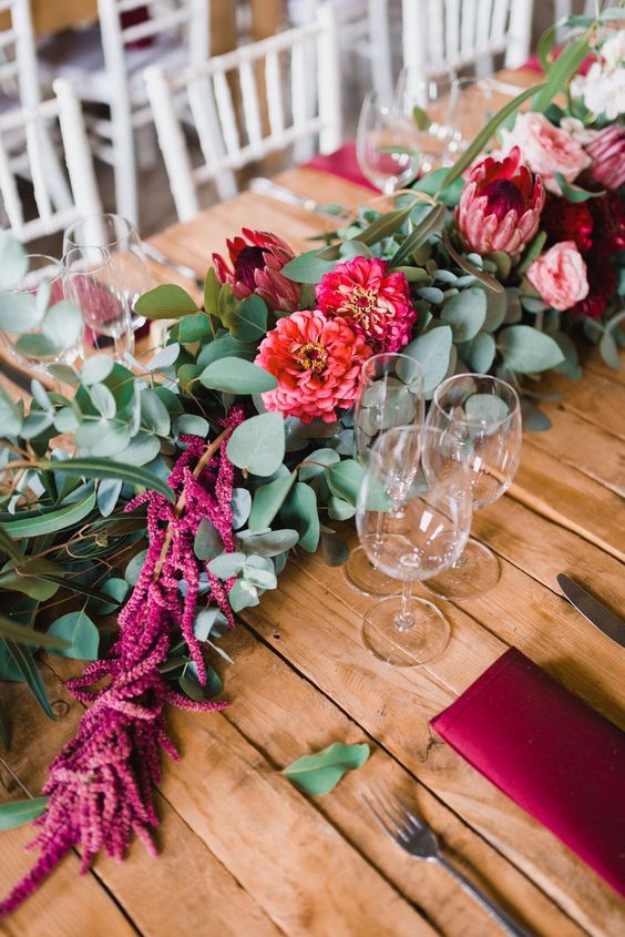 a chic wedding table runner of greenery, pink roses and mumes, amaranthus, king proteas instead of a centerpiece
