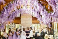 19 a romantic indoor wedding ceremony space with wisteria hanging down from the ceiling to make it feel more outdoorsy