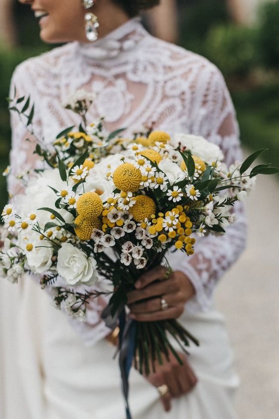 a pretty summer wedding bouquet of white roses, billy balls, mimosa, greenery and waxflower is a lovely and bright solution
