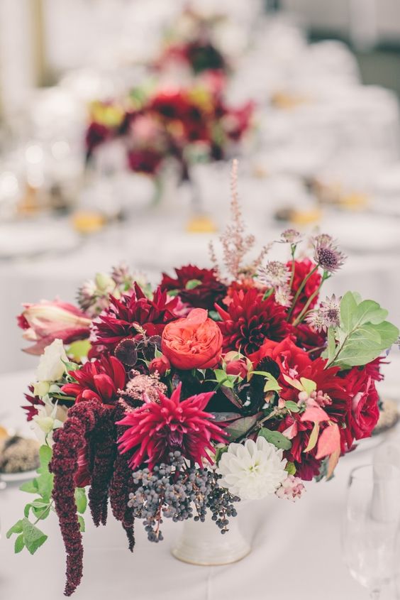 a bold wedding centerpiece of red dahlias, peony roses, amaranthus, greenery and grasses for a fall wedding