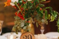 21 a chic fall wedding centerpiece of a wood slice, pumpkins, candles and blush and white blooms and fall foliage