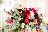22 a jewel-tone wedding centerpiece of dark callas, pink and white dahlias, pink peony roses, greenery and amaranthus is perfect for the fall