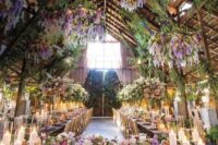 23 a beautiful indoor wedding reception space with greenery, wisteria, purple and white blooms all over seems to be a real indoor garden
