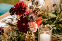24 a fall wedding centerpiece of burgundy mums, blush ones, deep purple blooms, thistles and bold fall foliage is easy to repeat