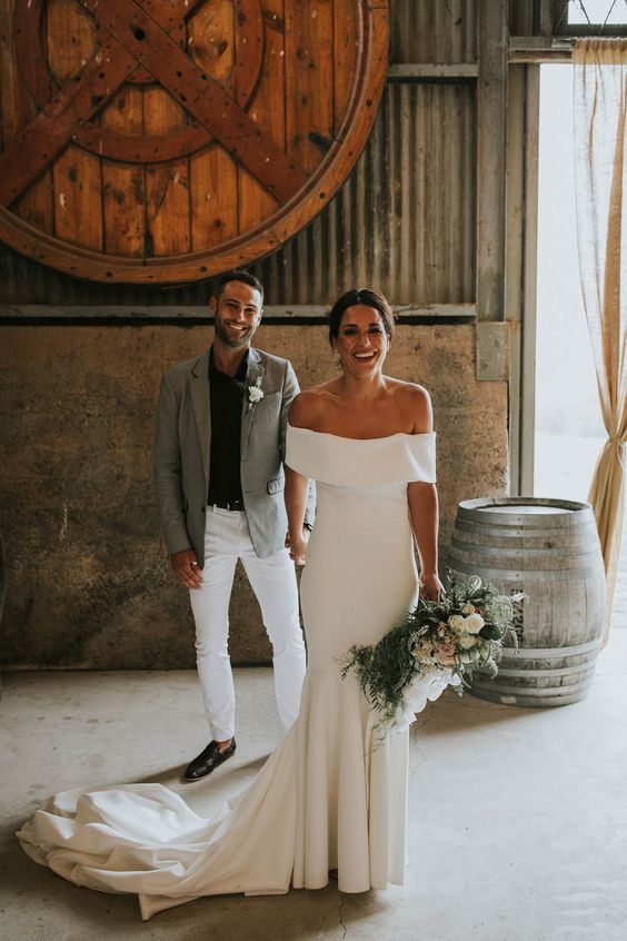 a modern plain off the shoulder mermaid wedding dress with a pleated skirt and a train is a fantastic idea for a modern wedding