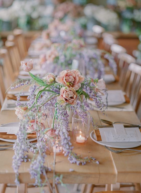 a chic and refined wedding centerpiece of wisteria and peachy blooms is a cool idea for a relaxed spring wedding