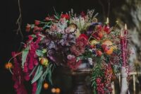 29 a luxurious wedding centerpiece with cascading blooms and foliage, colored fall leaves and berries