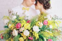 31 a bright and lush spring wedding centerpiece of blush and pink raunuculus, mimosa and greenery is jaw-dropping