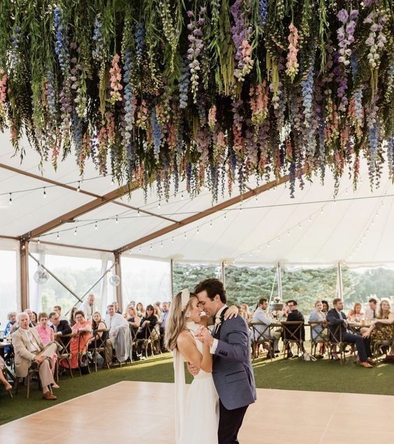 a dreamy wedding dancing floor with greenery, wisteria and some other blooms hanging down is a lovely idea