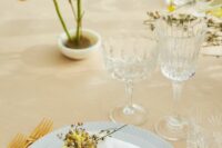 32 a delicate spring wedding tablescape with grey plates, mimosa and yellow poppies, chic modern cutlery and crystal glasses