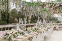 33 a fabulous outdoor flower-filled wedding reception space done with lots of peachy, lilac, pink, white blooms including wisteria and greenery