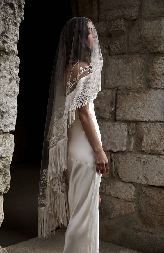 a super creative wedding veil with an embroidered edge and long fringe is a gorgeous idea for a boho bride