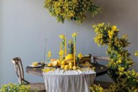 36 a jaw-dropping wedding sweetheart table surrounded with mimosa, with daffodils and yellow candles on the table