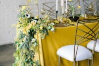 37 a lovely spring wedding table setting with a yellow tablecloth, mimosa, anemones and ranucnulus, daffodils and tall and thin candles