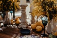 38 a Mediterranean wedding tablescape with mimosa centerpieces, pillar candles, lemons on the table, woven placemats and printed porcelain