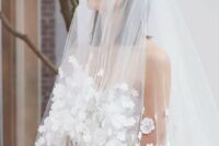 39 a cathedral veil with white flower applique and a matching wedding dress for a refined haute couture look at the wedding