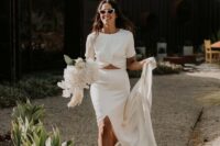 40 a modern wedding separate with a knotted crop top with short sleeves and a maxi skirt with a front slirt plus pink mules