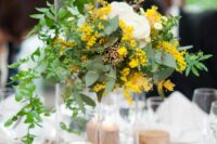 42 a rustic cluster wedding centerpiece with greenery, white ranunculus, mimosa and tree slices is a cool idea