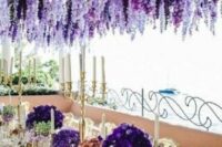 45 a refined and chic wedding tablescape with violet blooms and candelabras on the table and a gorgeous overhead floral installation of wisteria