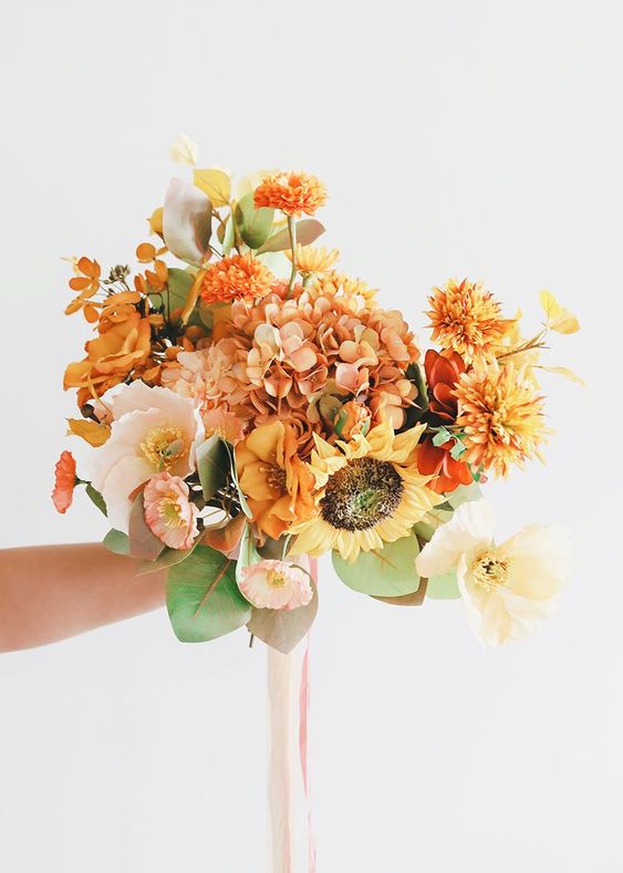 a bright wedding bouquet of hydrangeas, marigolds, sunflowers, peonies and greenery is a cool idea for a fall rustic bride