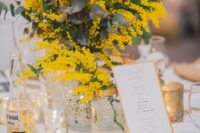 46 a stylish modern wedding tablescape with a mimosa and eucalyptus centerpiece, white porcelain, tan napkins and candles